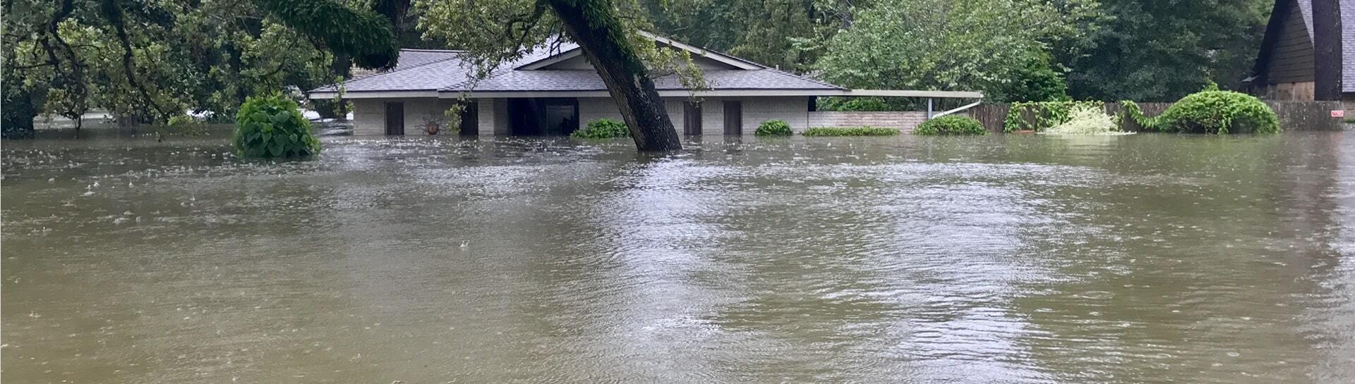 Flooded home with water surrounding the building.