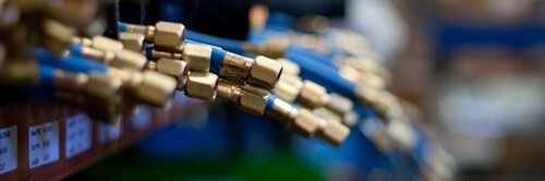 Close-up of brass hose fittings on a parts rack.